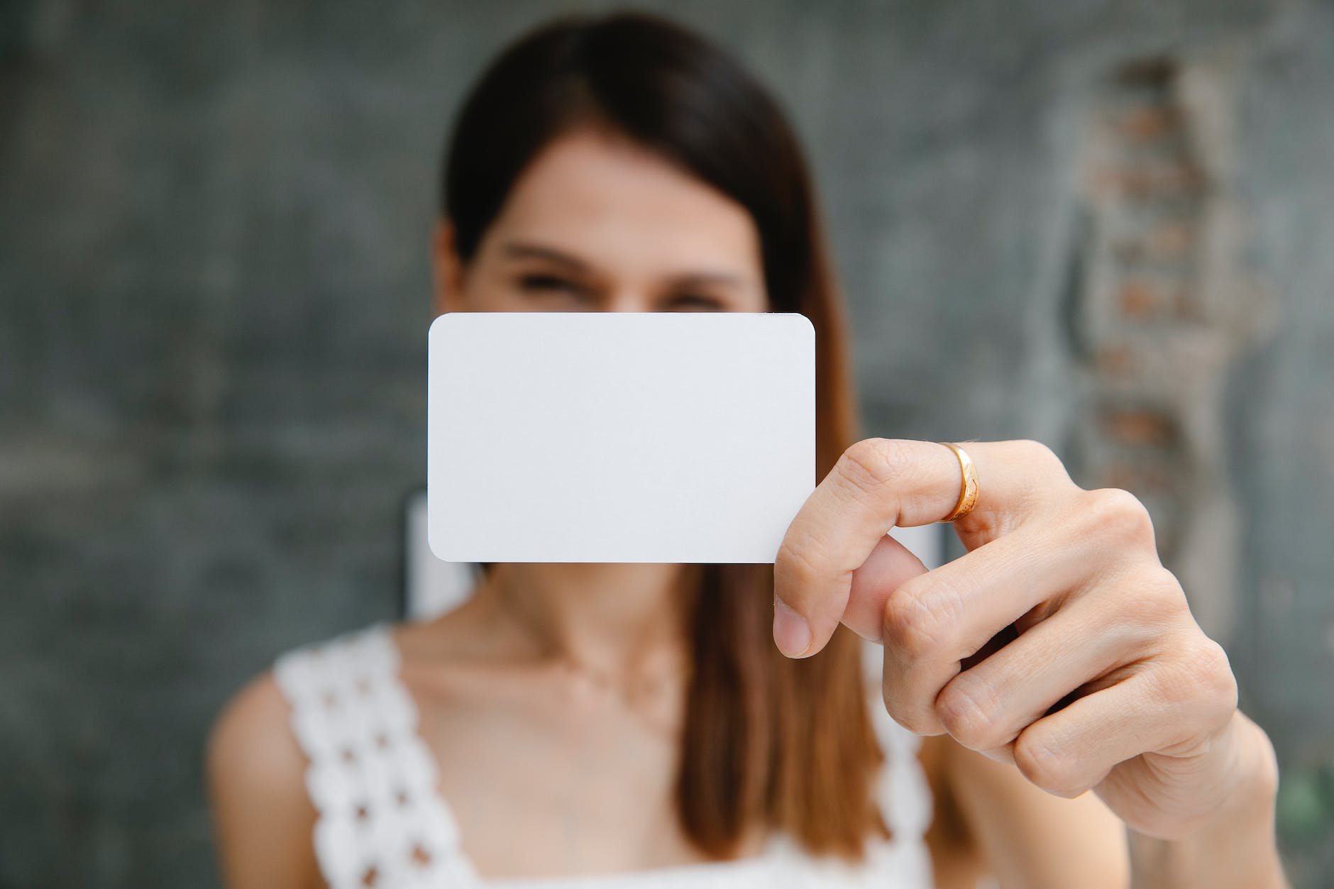 woman demonstrating blank business card in light room